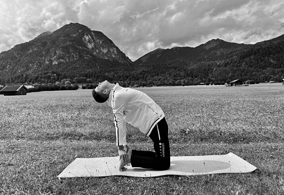 Ben macht Yoga vor Bergen